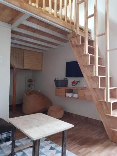 a living room with a wooden staircase and a table at Forelsket 2 in Da Lat