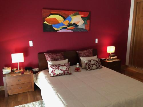 a bedroom with a bed with a painting on the wall at SOLAR DA SERRA-GuestHouse in Mangualde