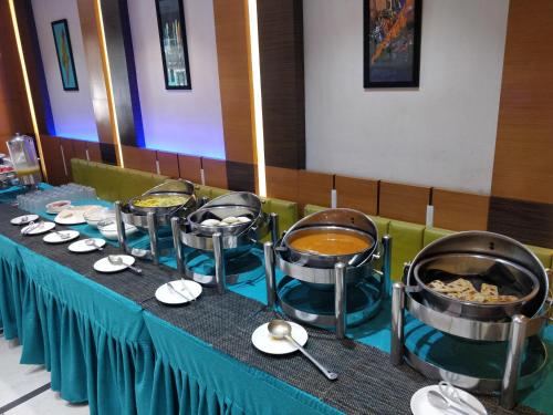 a table with bowls and plates of food on it at Hotel Royal Shelter in Vapi