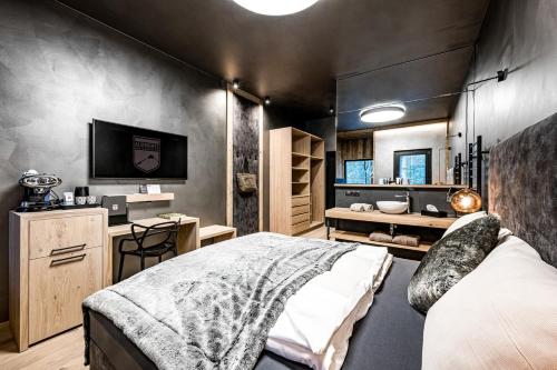 een slaapkamer met een bed en een tv in een kamer bij ALMMONTE PRÄCLARUM SUITES Design Hotel in Wagrain