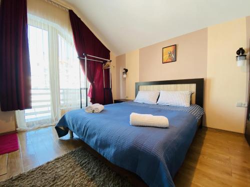 a bedroom with a blue bed with two towels on it at Villa Sun Valley in Bakuriani