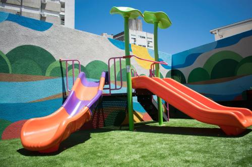 um parque infantil com um escorrega em frente a um mural em Holiday Inn Rosario, an IHG Hotel em Rosário