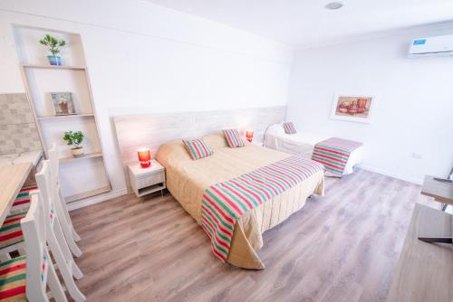 um quarto branco com uma cama e duas camas sidx sidx sidx em Augusta em Salta