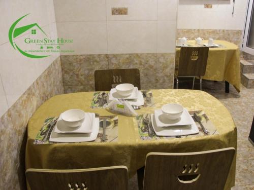 a dining room with a table and chairs with yellow table cloth at Green Stay house in Maputo