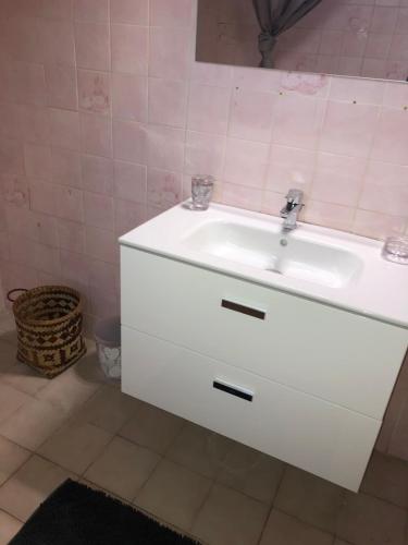 a white sink in a bathroom with pink tiles at TALIA in Bouillante