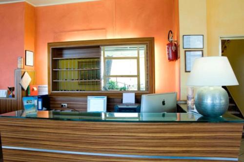 an office with a desk with a laptop and a lamp at Hotel Ambassador in Laigueglia