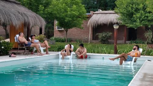 un grupo de personas sentadas alrededor de una piscina en Amaikén Suites en Nono