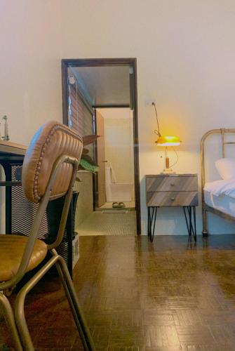 a bedroom with a chair and a bed and a mirror at Liu Xu Homestay in Tainan