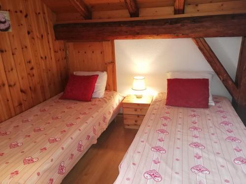 2 łóżka pojedyncze w pokoju z drewnianym sufitem w obiekcie crocus w mieście Saint-Martin-de-Belleville