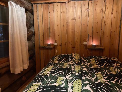a bedroom with a bed in a wooden wall at Levi Log Cabin - Viprakka 4A in Levi