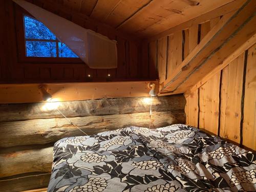 ein Schlafzimmer mit einem Bett in einer Holzhütte in der Unterkunft Levi Log Cabin - Viprakka 4A in Levi