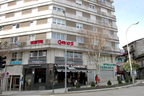 a large building on a city street with a store at Hostal Charo II in Santiago de Compostela