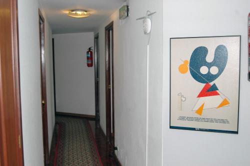 a hallway with a painting on the wall and a hallway sidx sidx at Hostal Charo II in Santiago de Compostela