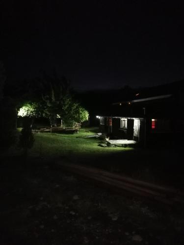 a house lit up at night with a tree in the yard at Casa Rural Huillinco in Huillinco