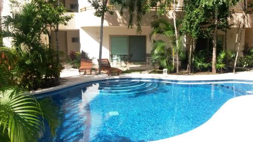 een zwembad voor een gebouw met bomen bij Stay in Tulum! in Tulum