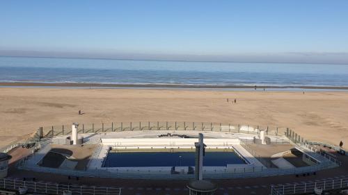 a view of a beach with a swimming pool at Oostduinkerke Apartments in Oostduinkerke