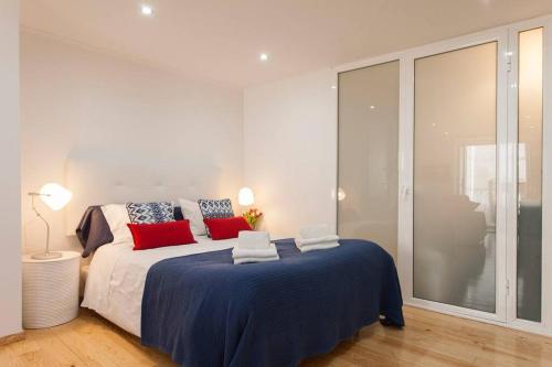 a bedroom with a large bed with red and blue pillows at Charming Studio in Mouraria in Lisbon