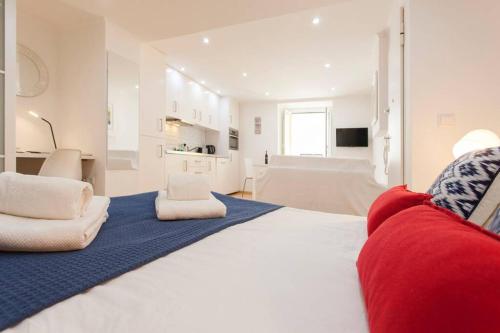 a bedroom with a large bed with a red couch at Charming Studio in Mouraria in Lisbon