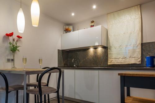 a kitchen with white cabinets and a table with chairs at Rinkus in Saulkrasti