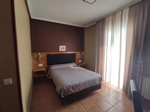 a bedroom with a bed and a large window at Hotel Ciudad de Jódar in Jódar