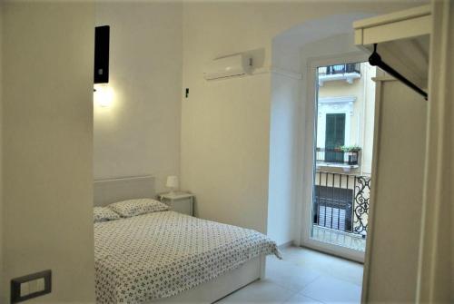 Habitación pequeña con cama y ventana en Appartamento Aurora, en Bari