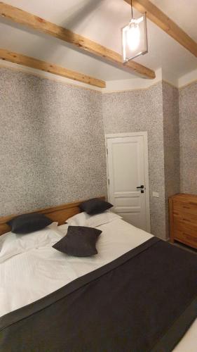 a bedroom with a large white bed with black pillows at JINJOTEL Gyumri in Gyumri