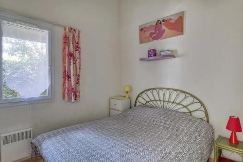 una camera da letto con un letto e una finestra di Location Le Samaria Villa 29 - Mail de Rochelongue a Cap d'Agde