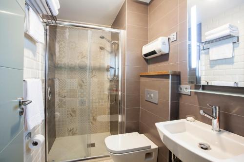 a bathroom with a sink, toilet and shower at Hotel Okako San Sebastian in San Sebastián