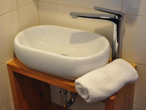 a white sink sitting on a wooden vanity in a bathroom at CHILL&SLEEP Bad Ischl in Bad Ischl