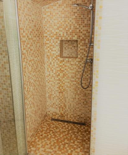 a shower in a bathroom with a tiled floor at Sleep2Fly Hamburg-Airport in Hamburg