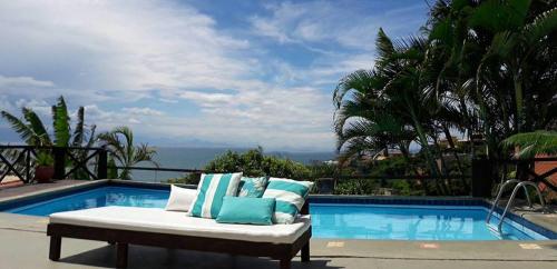 a couch sitting next to a swimming pool at Pousada Vila do Sol in Búzios