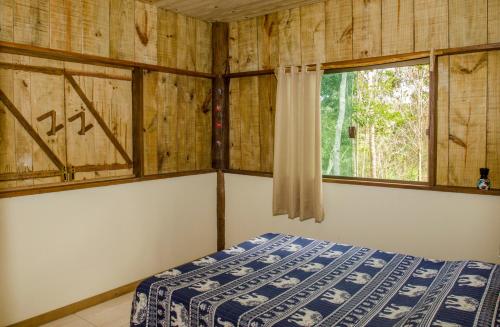 1 dormitorio con cama y ventana en Sitio recanto da natureza, en Serra Grande