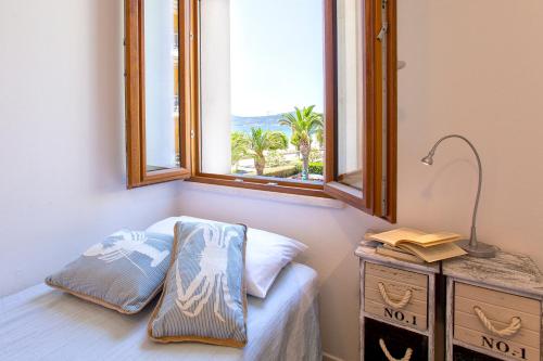 een kamer met een raam en een bed met een kussen bij B&B AL MARE in Alghero