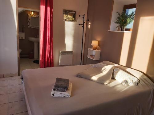 a bed with two towels on it in a bedroom at Les Gites de la Valette in Ménil-Hubert-sur-Orne