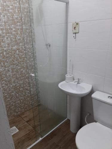y baño con ducha, aseo y lavamanos. en Residencial Leal, en Florianópolis