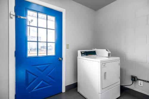 a blue door in a laundry room with a washing machine at SureStay Hotel by Best Western Oklahoma City West in Oklahoma City