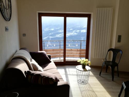 a living room with a couch and a large window at Maison de l'Epine -spa- Versant du soleil in Granier