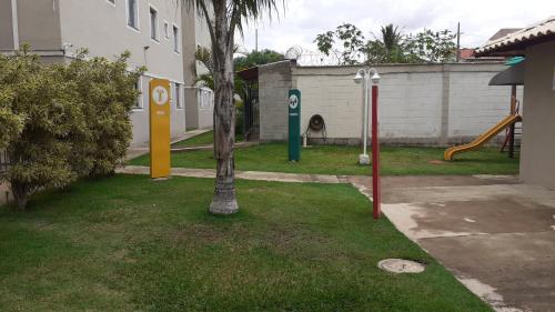 un parque infantil con un árbol y un tobogán en un patio en Residencial savassi, en Betim