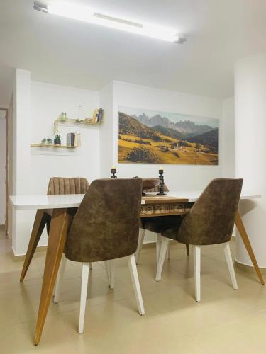 a dining room with a table and two chairs at Uyut apartments in Majdal Shams