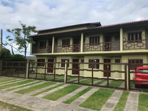 a house with a fence in front of it at Pousada Recanto da Barra Imbé in Imbé