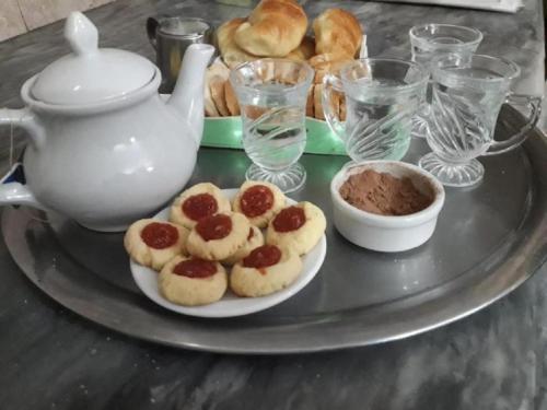 圣特雷西塔Hostel Megaró的桌上放着一盘糕点和一只茶壶。