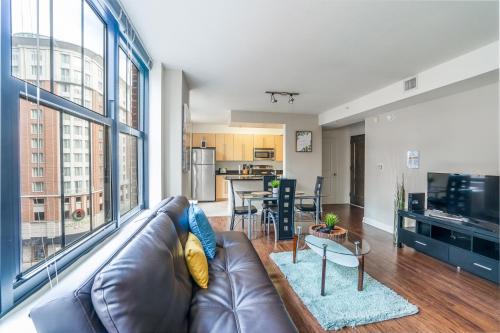 a living room with a leather couch and a large window at Heaven On Baltimore at Harborfront in Baltimore