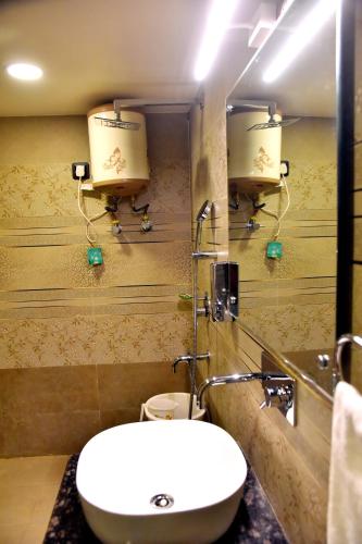 a bathroom with a sink and a toilet and a mirror at HOTEL VINAYAK in Lucknow