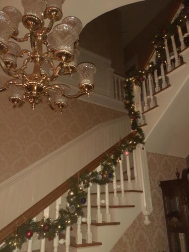 a staircase with a chandelier and christmas decorations at Queens Chamber w King Heavenly Bed at Nottingham Place in Wise in Wise