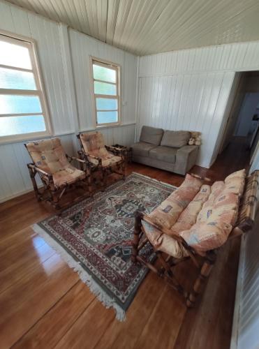 a living room with a couch and chairs and a rug at Aconchego da Vó Méia in Urubici