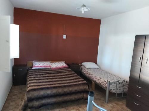 a small room with two beds and a cabinet at Tierras Blancas Nihuil in El Nihuil