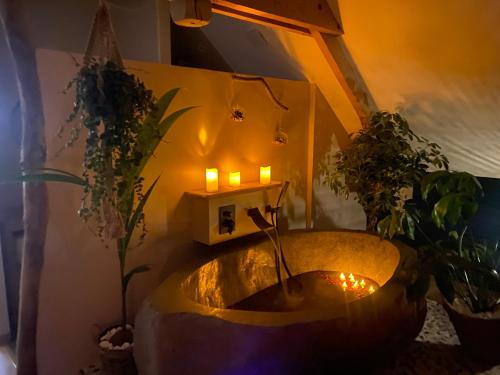 a bathtub with candles and plants in a room at Ferme "les Flaquettes" in Guînes