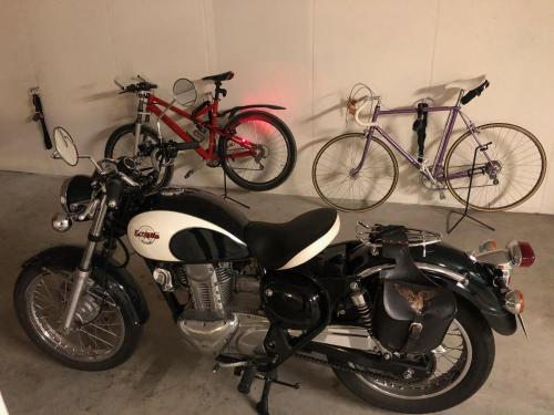 a motorcycle parked next to two bikes in a garage at Engelberg 24h check in in Wangen im Allgäu