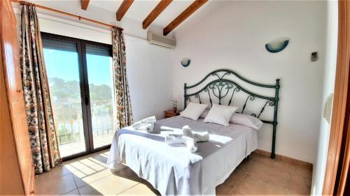 a bedroom with a large bed and a large window at Villa Costa in Moraira
