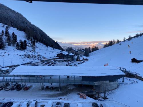 a building covered in snow next to a mountain at Chez Chantal in Siviez
